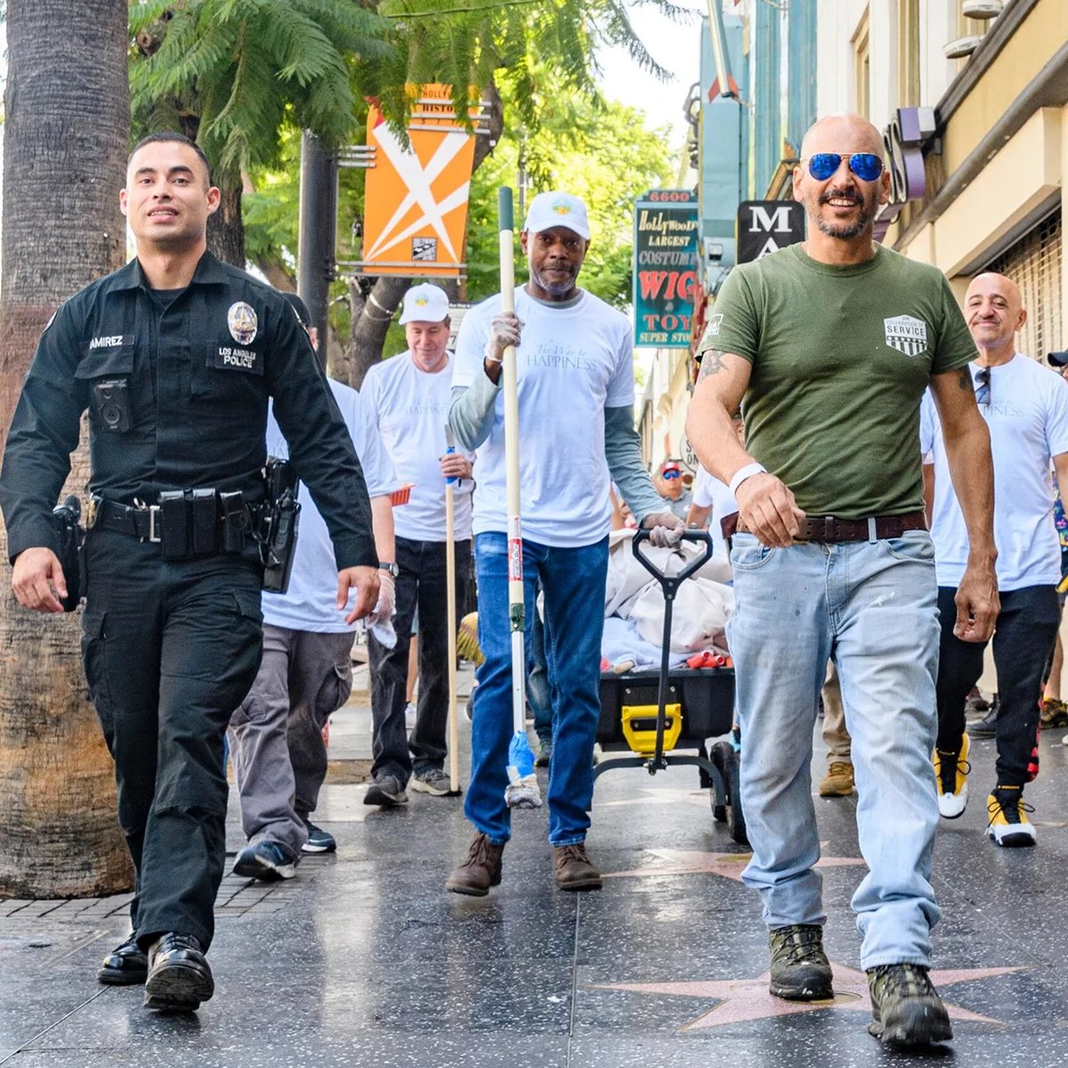 Důstojník Policejního sboru Los Angeles a dobrovolníci pochodovali s vybavením, aby zkrášlili výkladní skříně podél chodníku slávy Hollywood Boulevard