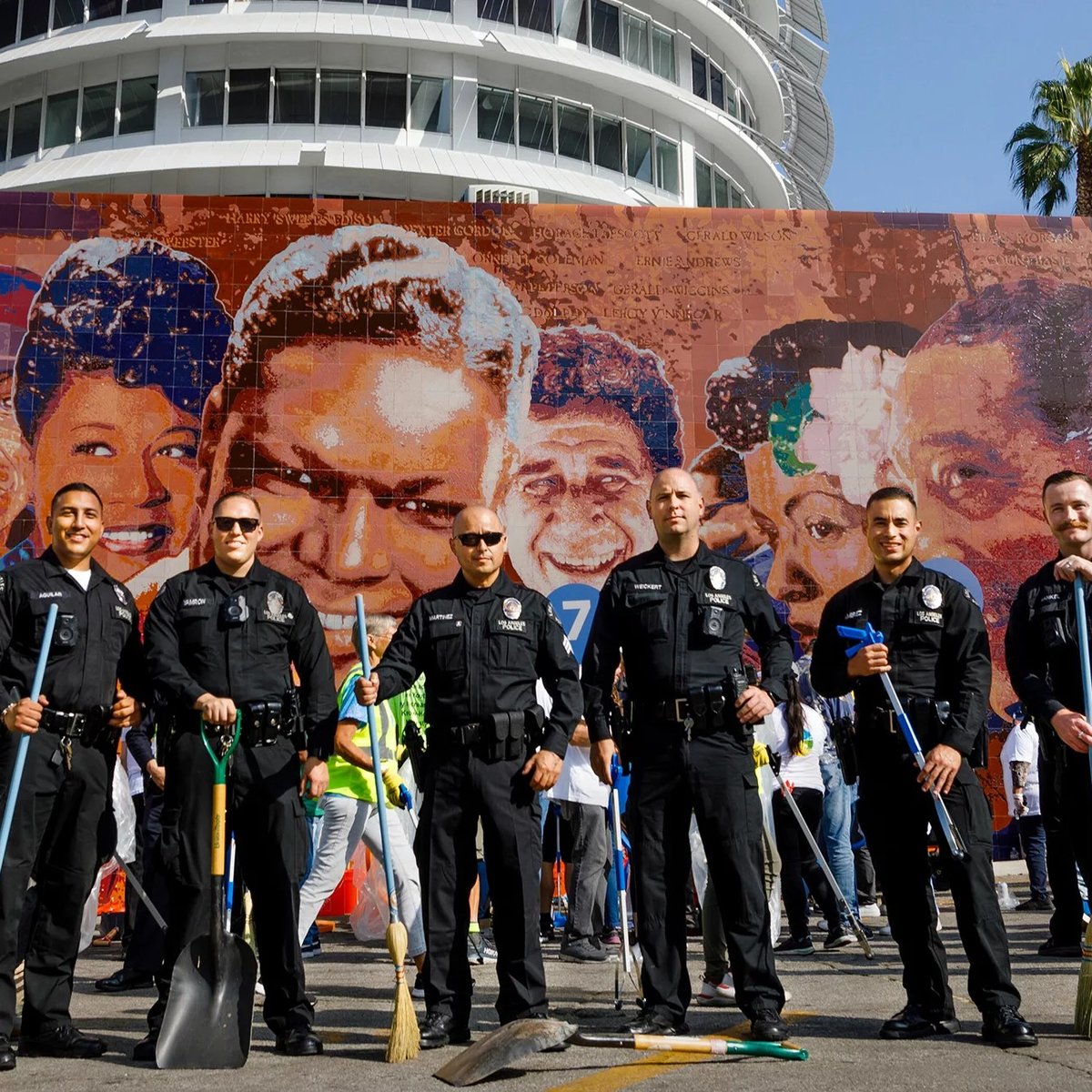 Důstojníci Policejního sboru Los Angeles se seřadí před nástěnnou malbou na budově Capitol Records na začátku úklidu komunity Hollywood Faith and Blue Weekend