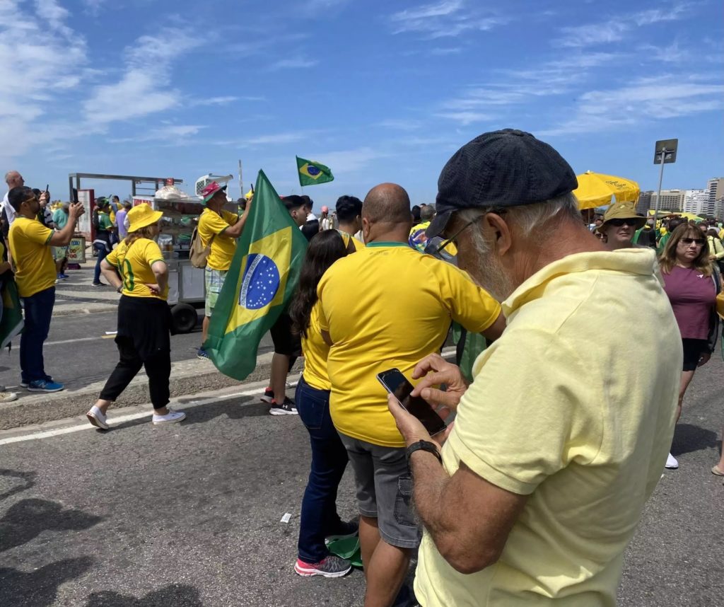Brazilský muž kontroluje svůj smartphone během demonstrace v Rio de Janeiru 7. září 2022.